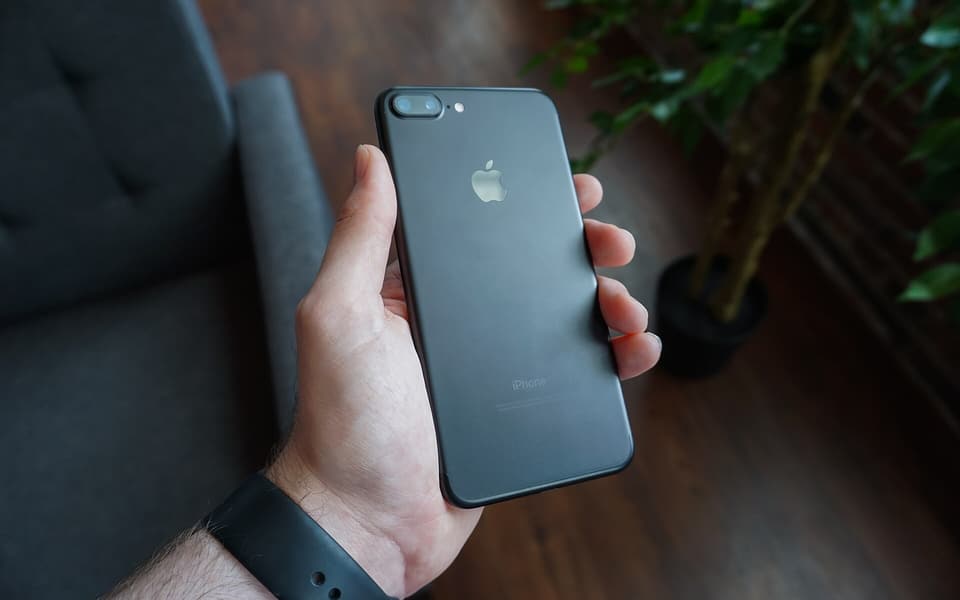 Mano sosteniendo un celular negro con la pantalla encendida