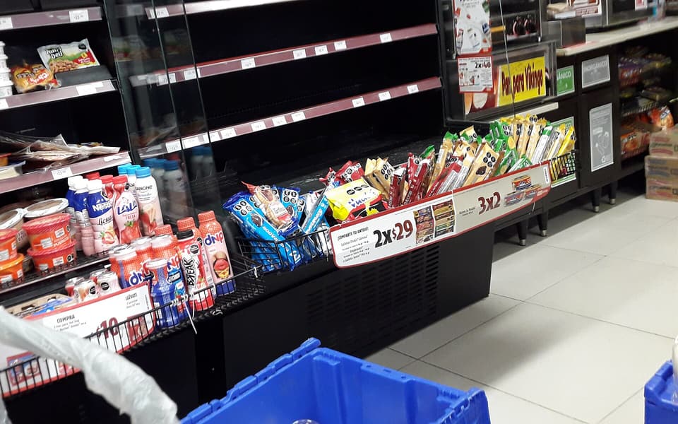 Interior de una tienda OXXO en Mazatlán: pasillos, refrigeradores y la caja al fondo